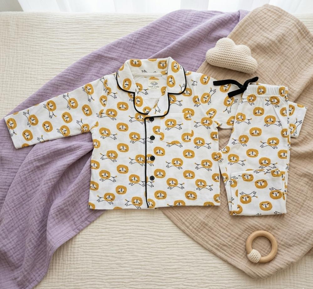 Children's pajama set with lion pattern on a textured surface