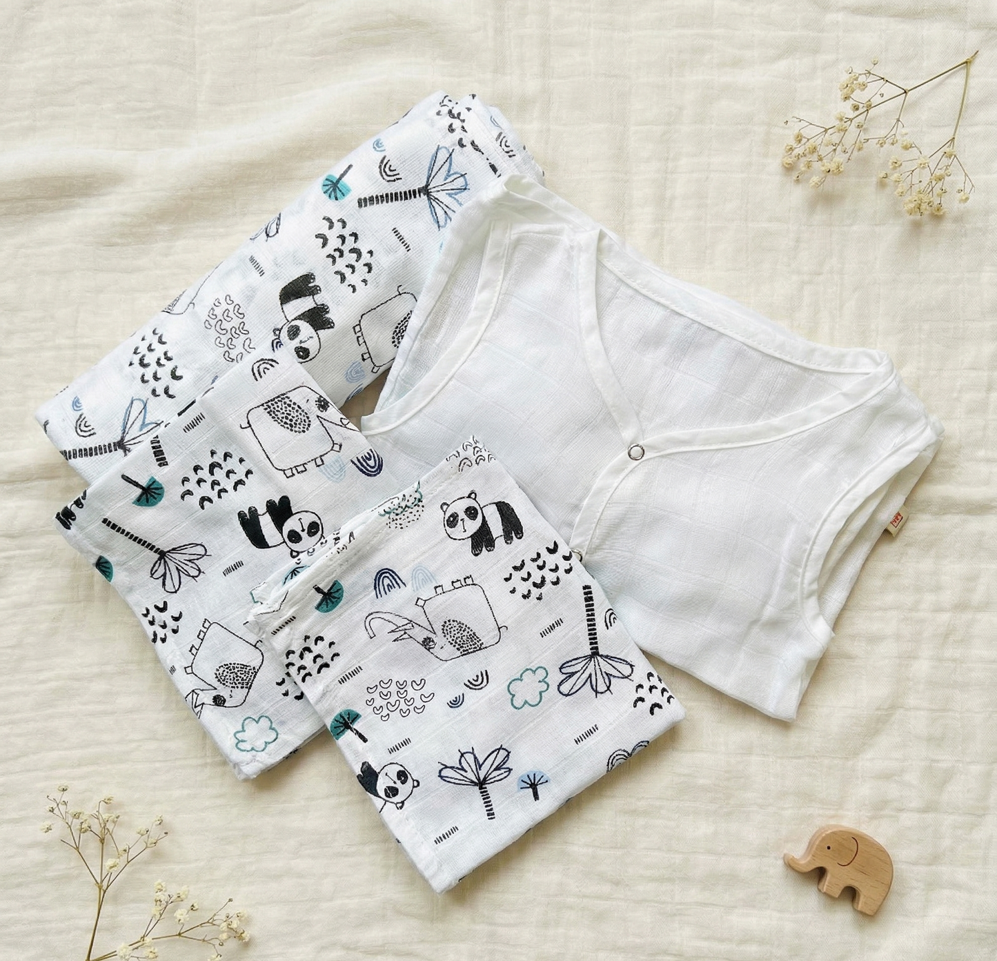 Baby outfit with white shirt and patterned shorts on a light background