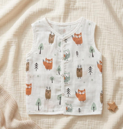 Baby vest with fox and owl pattern on a soft beige fabric background