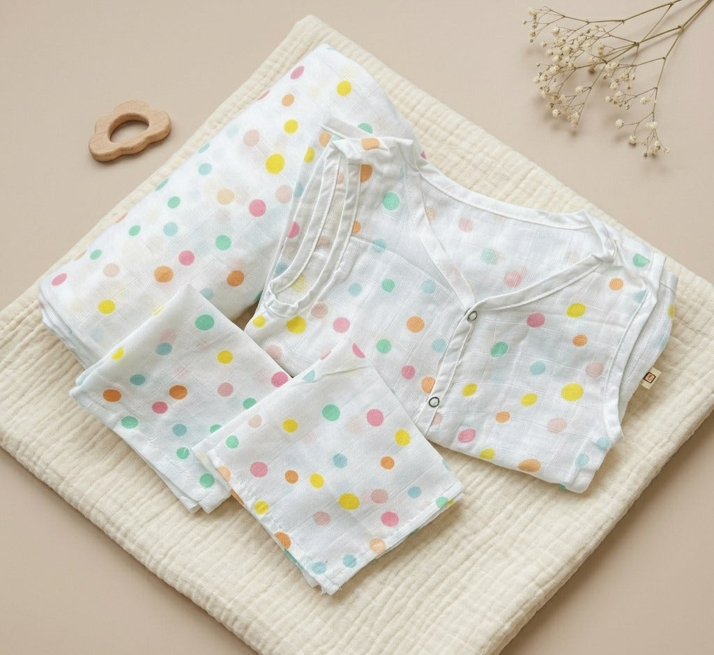 Set of baby clothes with colorful polka dots on a beige surface