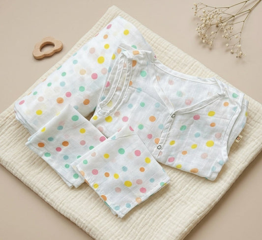 Set of baby clothes with colorful polka dots on a beige surface