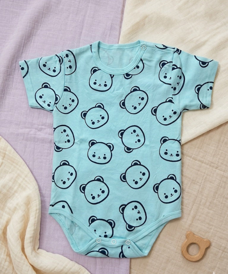 Light blue baby onesie with black bear pattern on a textured surface