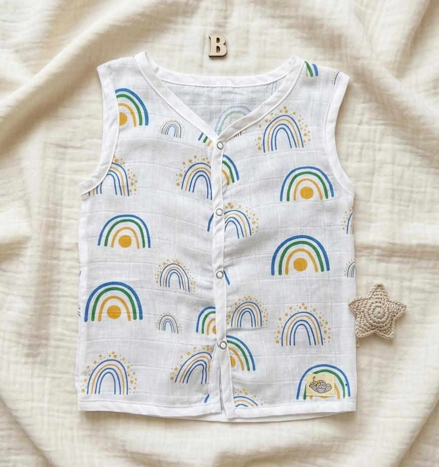 Baby vest with rainbow pattern on a soft beige fabric background