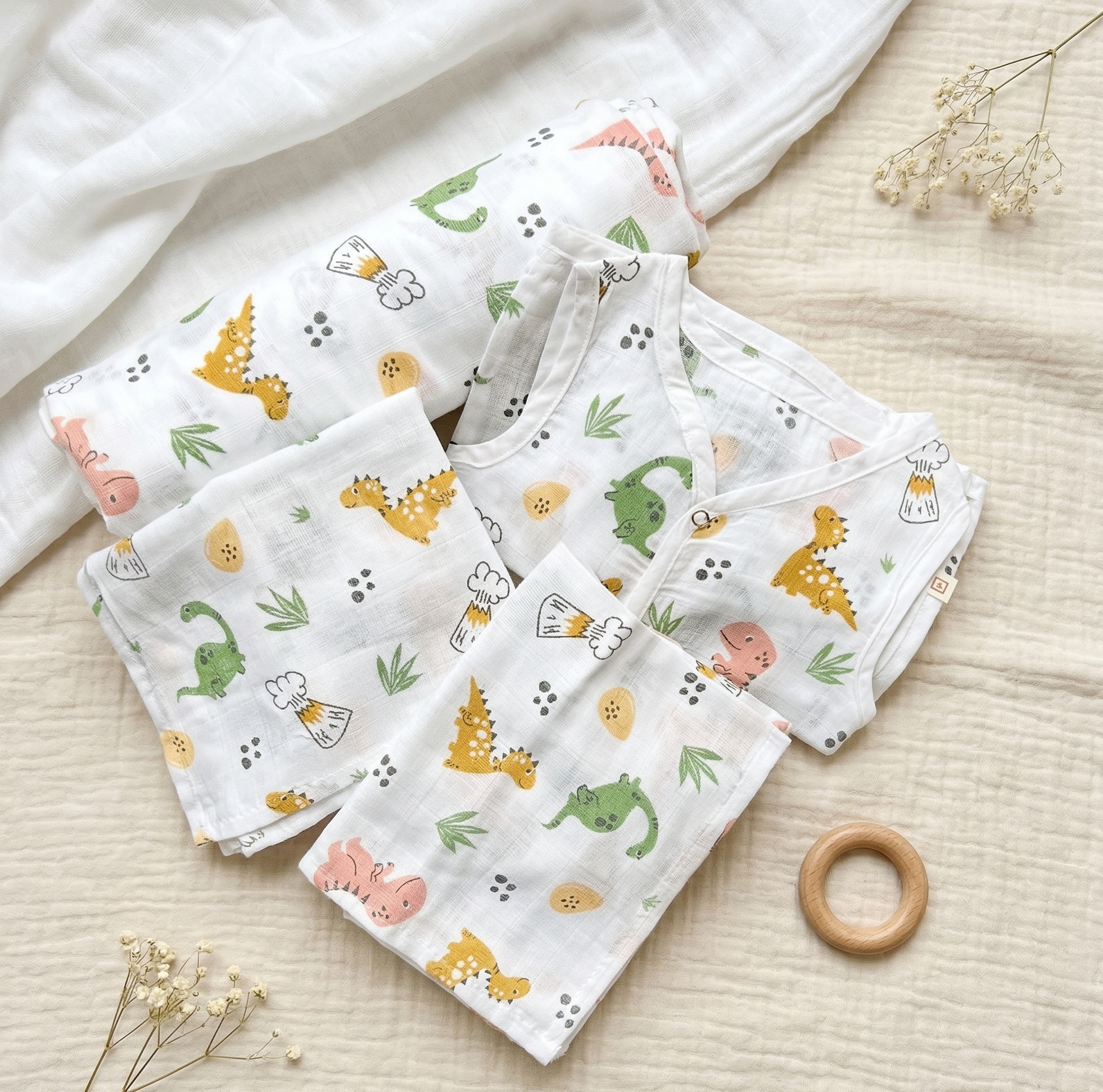 Set of baby blankets with animal patterns on a light wooden surface