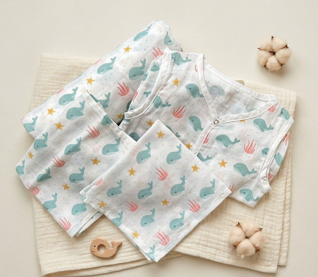 Baby clothing set with whale pattern on a neutral background