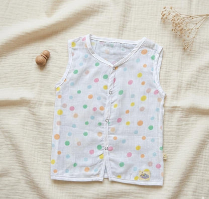 Baby vest with colorful polka dots on a beige fabric background